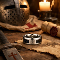 Bague de l’Ascension du Croisé en acier inoxydable dans un décor médiéval avec casque, épée, parchemin, bougie et croix templière
