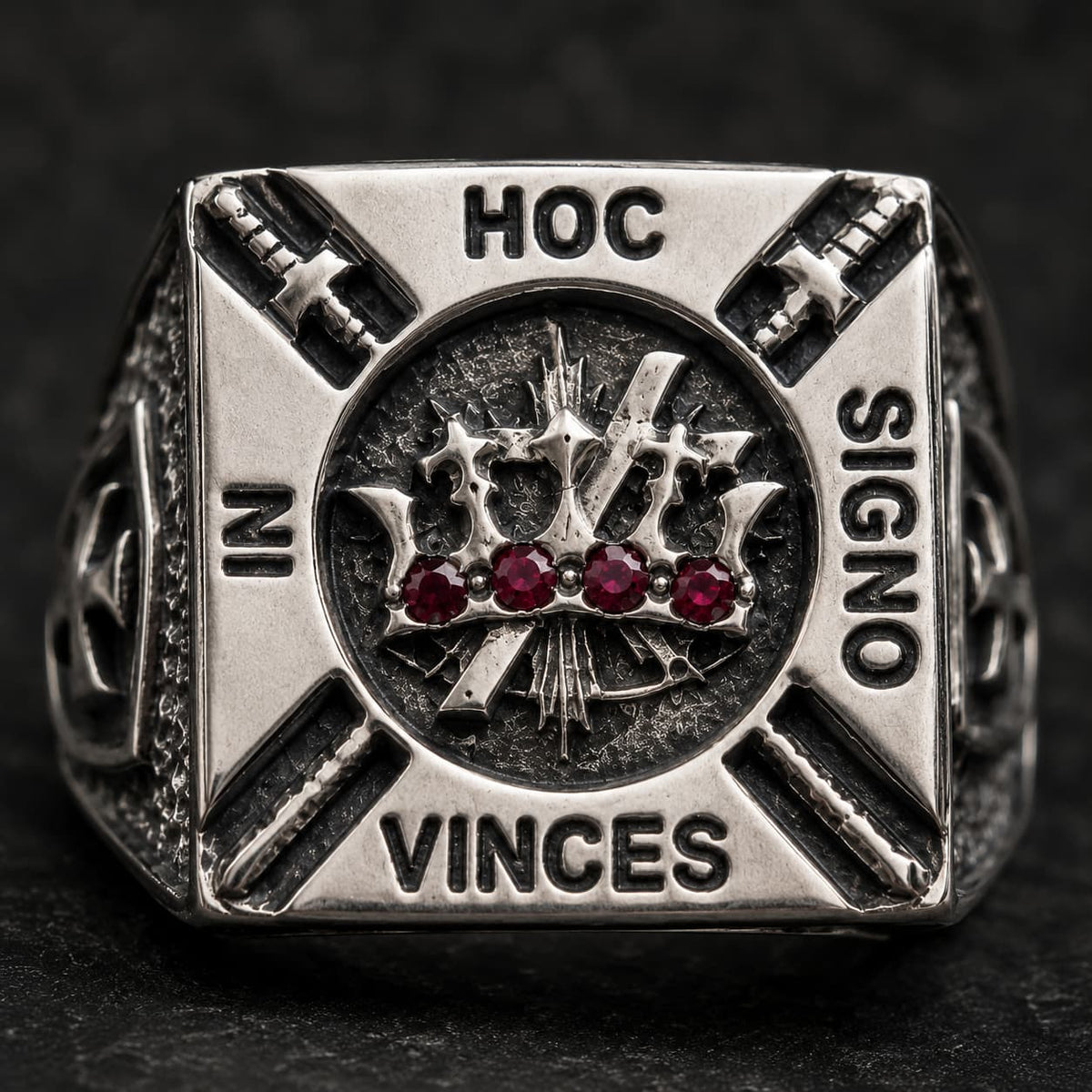 Gros plan de la Bague de la Confrérie en acier inoxydable avec couronne, pierres rouges et devise gravée