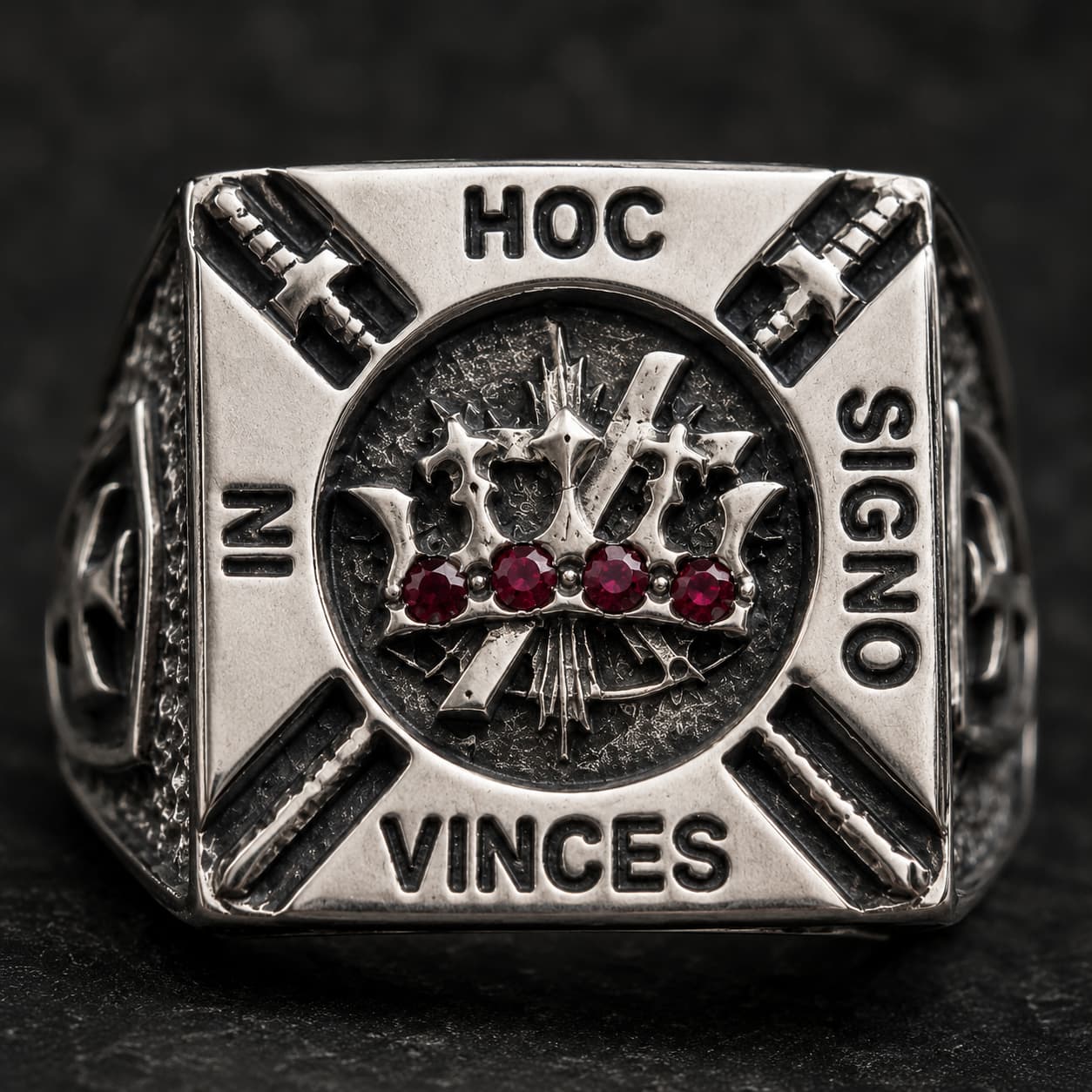 Gros plan de la Bague de la Confrérie en acier inoxydable avec couronne, pierres rouges et devise gravée