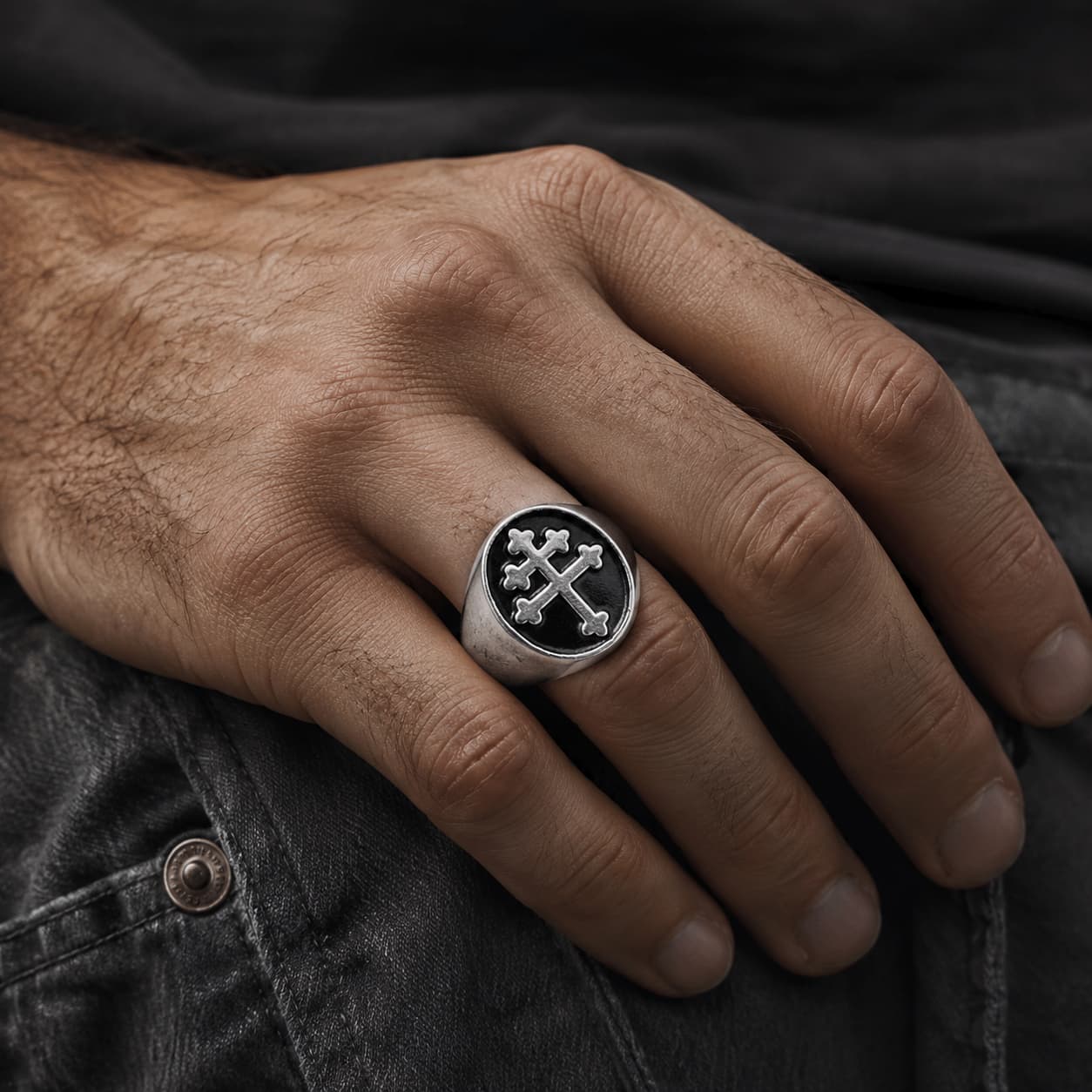 Bague Croix de Lorraine en acier inoxydable portée à la main par un homme sur fond sombre