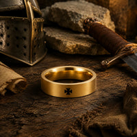 Bague Croix Pattée du Templier en acier inoxydable doré présentée dans un décor médiéval