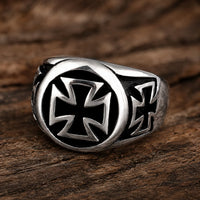 Bague de l’Annonciation en acier inoxydable avec croix templière noire et argent posée sur bois
