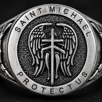 Gros plan de la Bague de la Prière de l’Archange en argent 925 sterling avec ailes, croix et inscription Saint Michael Protect Us