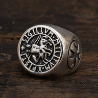 Bague du Chevalier en acier inoxydable avec sceau templier et inscription Sigillum Militum Xpisti posée sur bois rustique