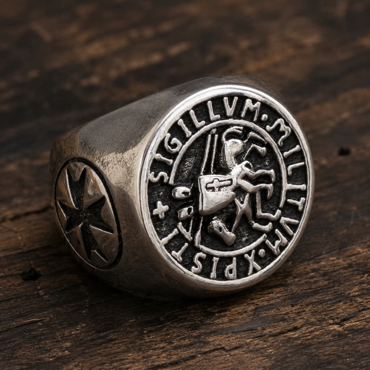 Bague du Chevalier en acier inoxydable vue de côté avec sceau templier et croix latérale sur bois rustique