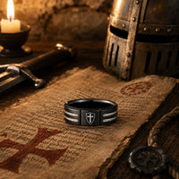 Bague de l’Écuyer en acier inoxydable noire dans un décor médiéval avec parchemin, casque, épée et bougie