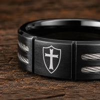 Gros plan de la Bague de l’Écuyer en acier inoxydable noire avec croix templière sur bouclier