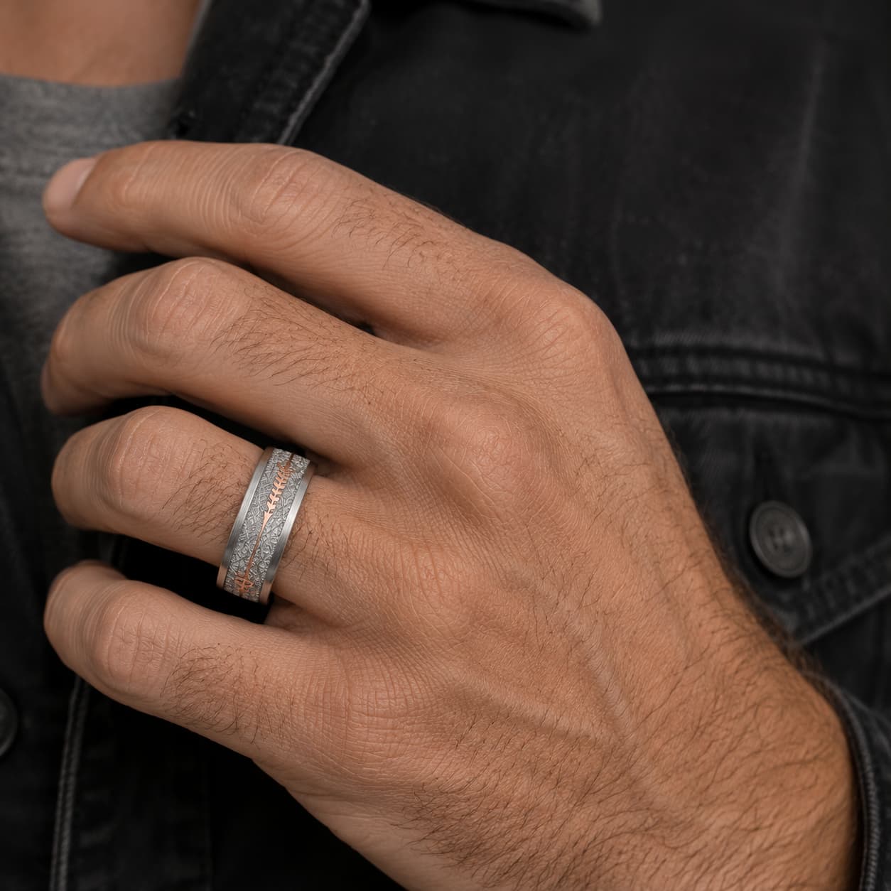 Bague Flèche Sacrée en tungstène portée à la main avec motif flèche rose