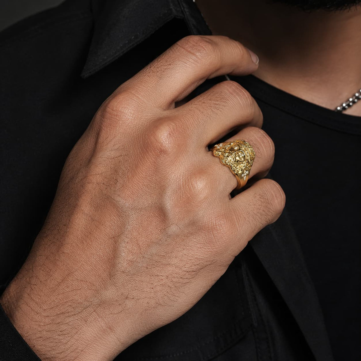 Bague Foi en Christ en acier inoxydable doré portée à la main par un homme en tenue noire