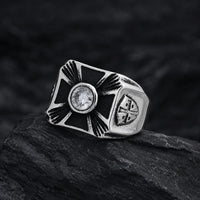 Bague Héritage des Croisés en acier inoxydable posée sur pierre noire avec croix noire, pierre centrale et détails argentés