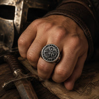 Bague Puissance de l'Archange Michel en acier inoxydable portée à la main dans un décor médiéval