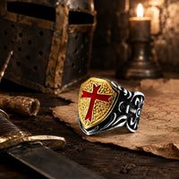 Bague Royale du Temple en acier inoxydable présentée dans un décor médiéval templier avec casque, parchemin et bougie