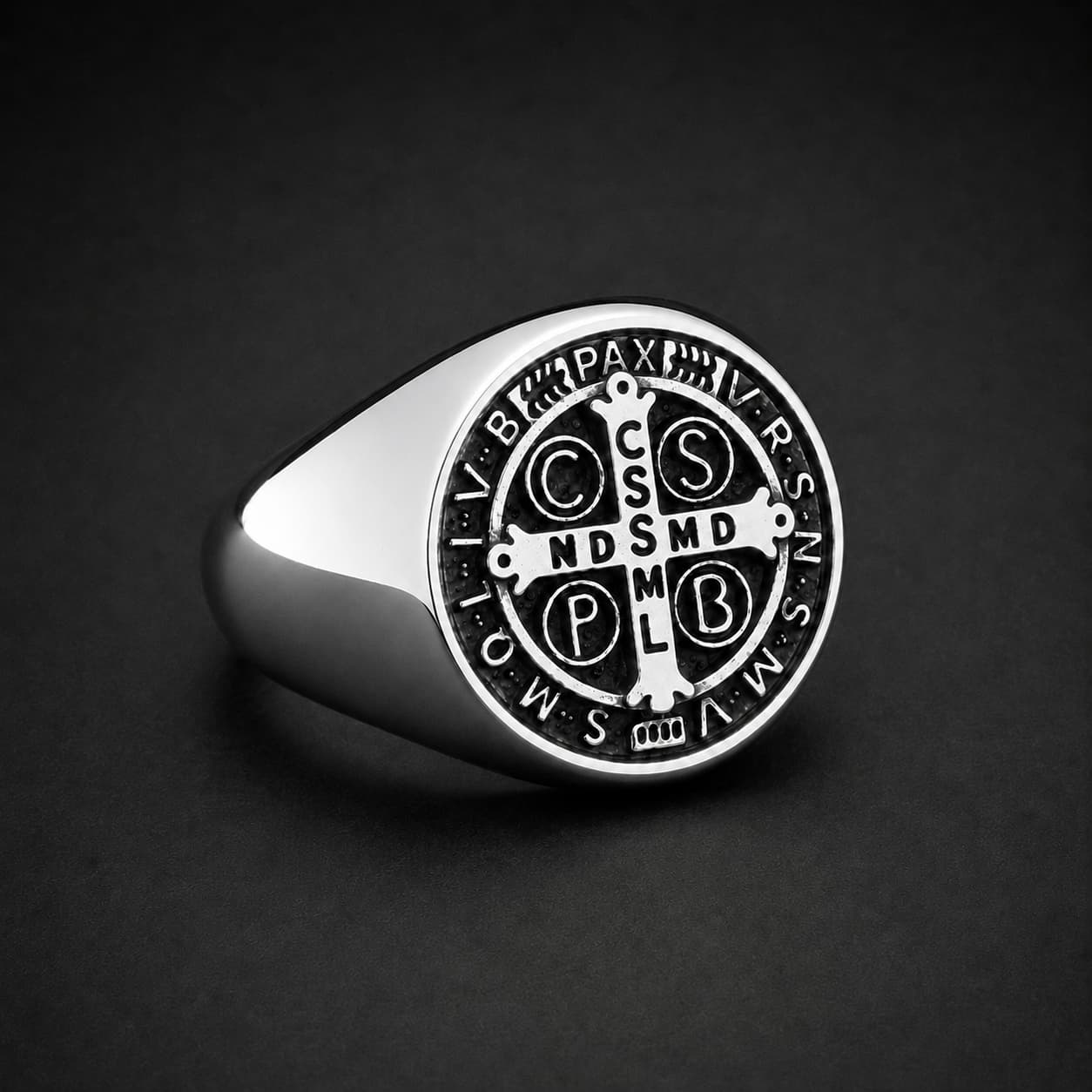 Bague Sacrée des Bénédictins en acier inoxydable argenté avec croix et inscriptions noires sur fond sombre