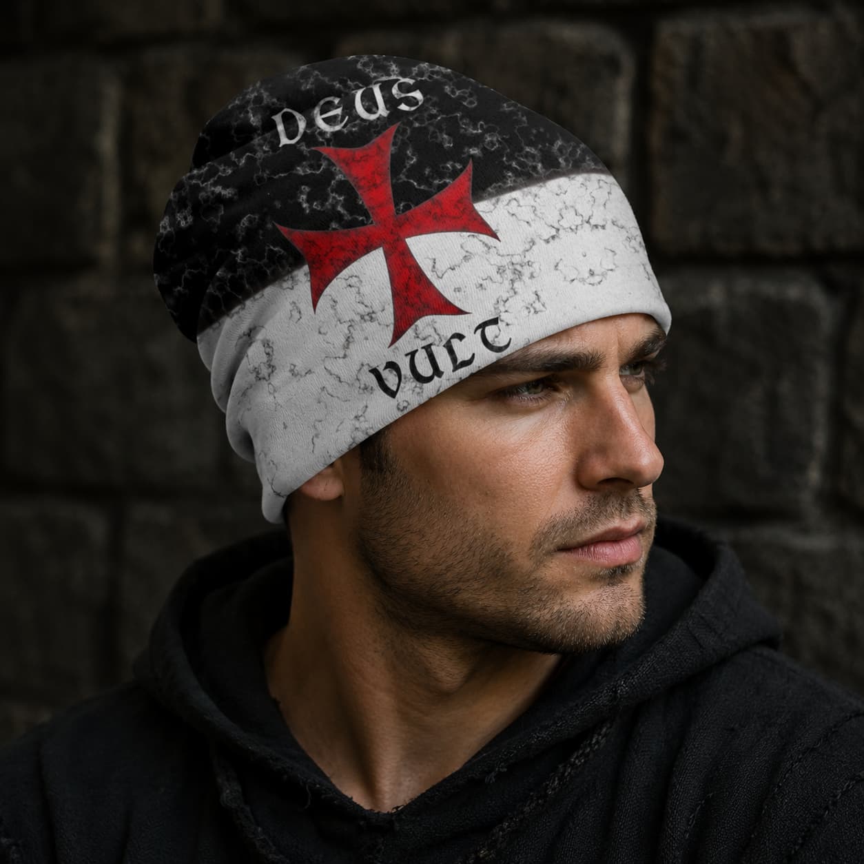 Bonnet Deus Vult en polyester et coton porté par un homme avec tenue sombre sur fond de pierre.
