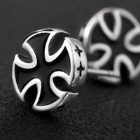 Gros plan des Boucles d’Oreilles Croix du Fief en acier inoxydable montrant la croix noire et les contours argentés.