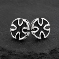 Boucles d’Oreilles Croix du Fief en acier inoxydable avec croix noire et argentée sur ardoise sombre.