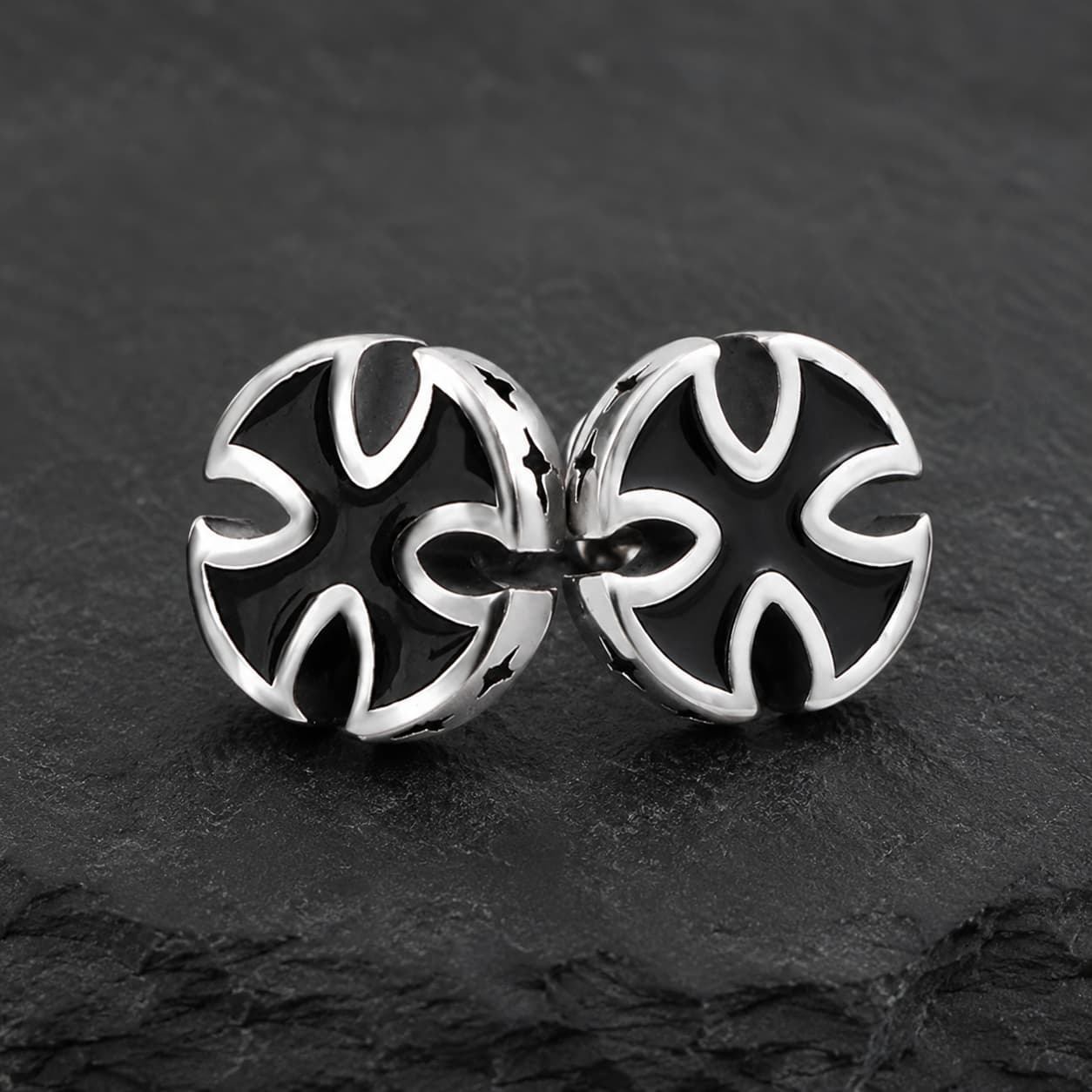 Boucles d’Oreilles Croix du Fief en acier inoxydable avec croix noire et argentée sur ardoise sombre.