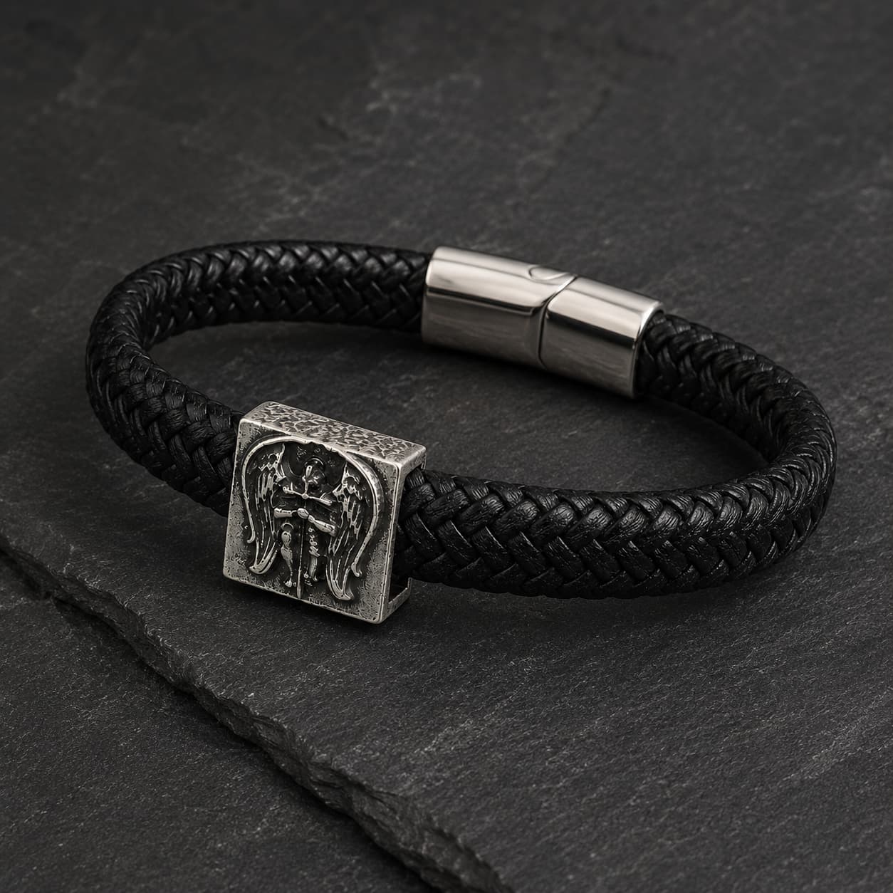 Gros plan du médaillon archange Michel sur bracelet en cuir tressé noir et acier inoxydable