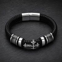 Bracelet de la Basilique en cuir tressé noir avec croix métallique et acier inoxydable sur ardoise sombre