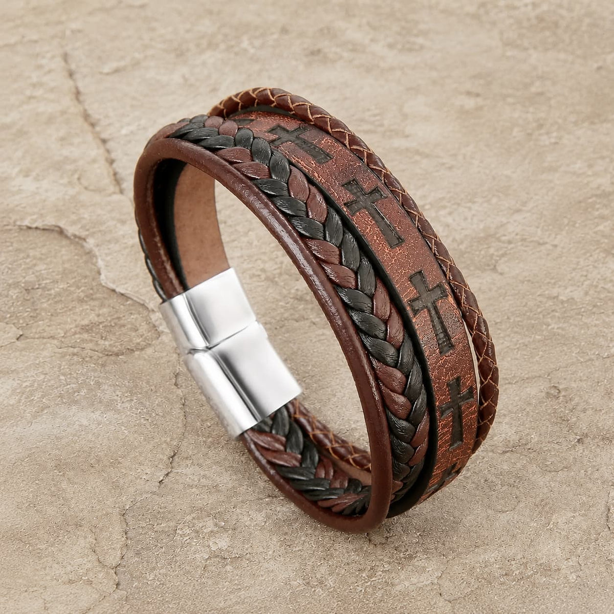 Bracelet du Croisé Templier en cuir tressé marron et alliage de cuivre en vue angle 3/4 sur pierre médiévale claire