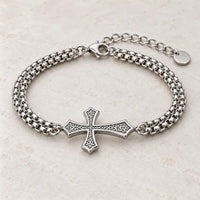 Bracelet de la Croix du Chevalier argenté présenté sur fond pierre claire