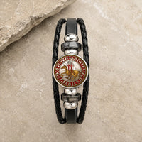 Bracelet Croix du Temple en cuir tressé noir avec médaillon sceau templier rouge et or en alliage métallique premium sur pierre médiévale claire