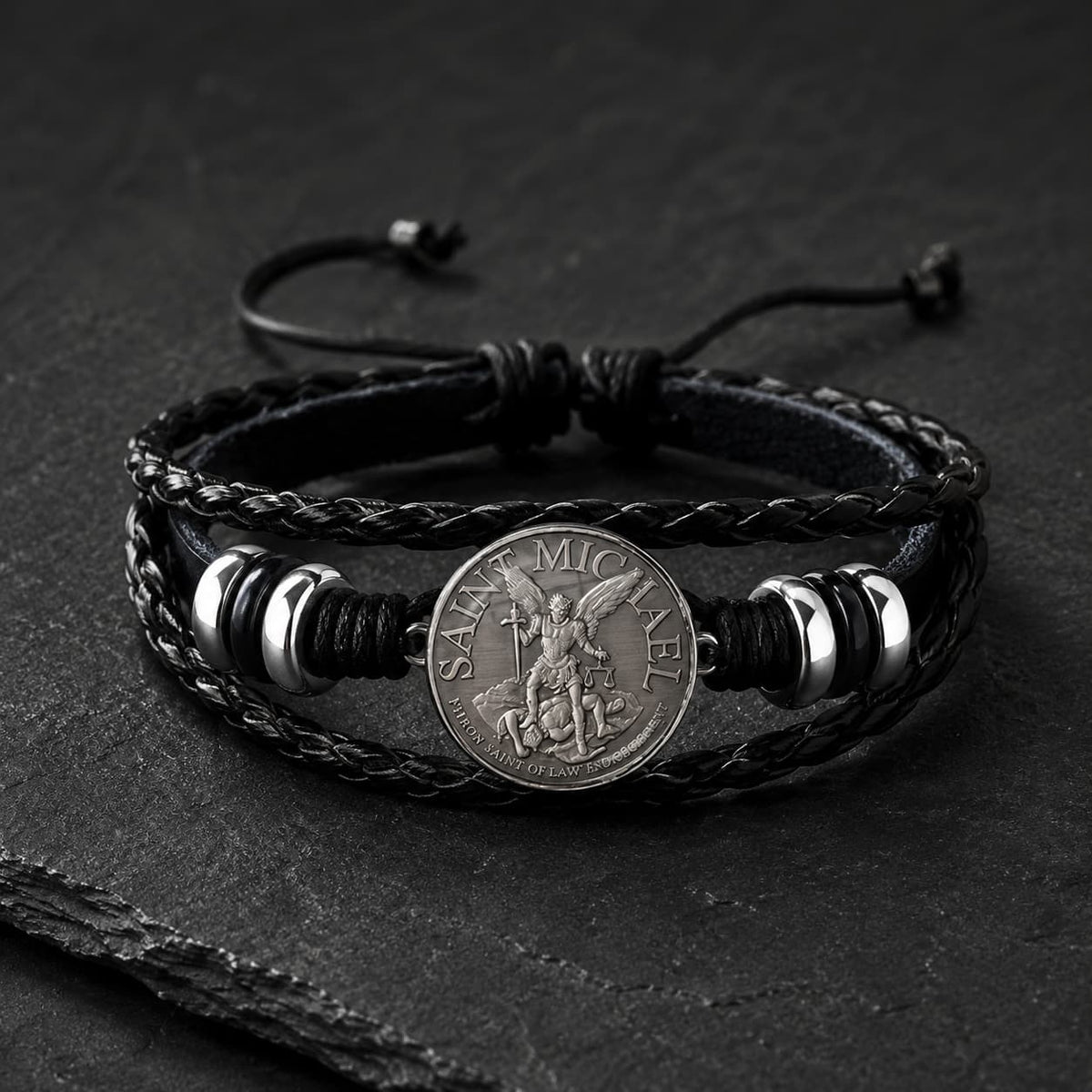 Bracelet de l’Archange Protecteur en cuir tressé noir avec médaille Saint Michel argentée sur ardoise sombre