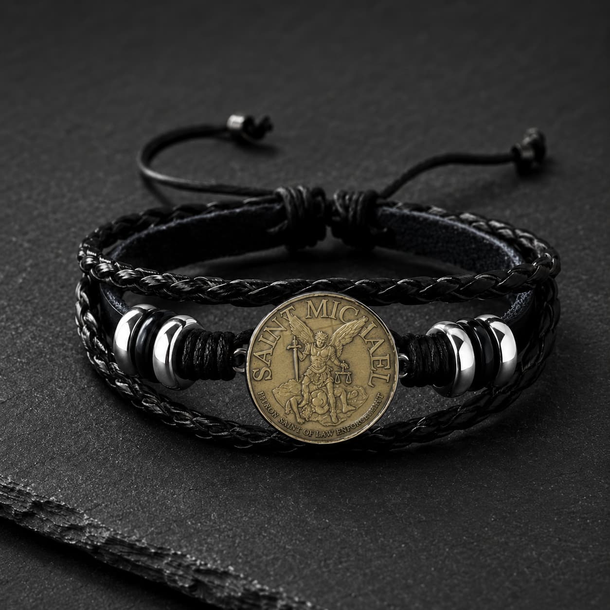 Bracelet de l’Archange Protecteur en cuir tressé noir avec médaille Saint Michel bronze et alliage métallique sur ardoise sombre