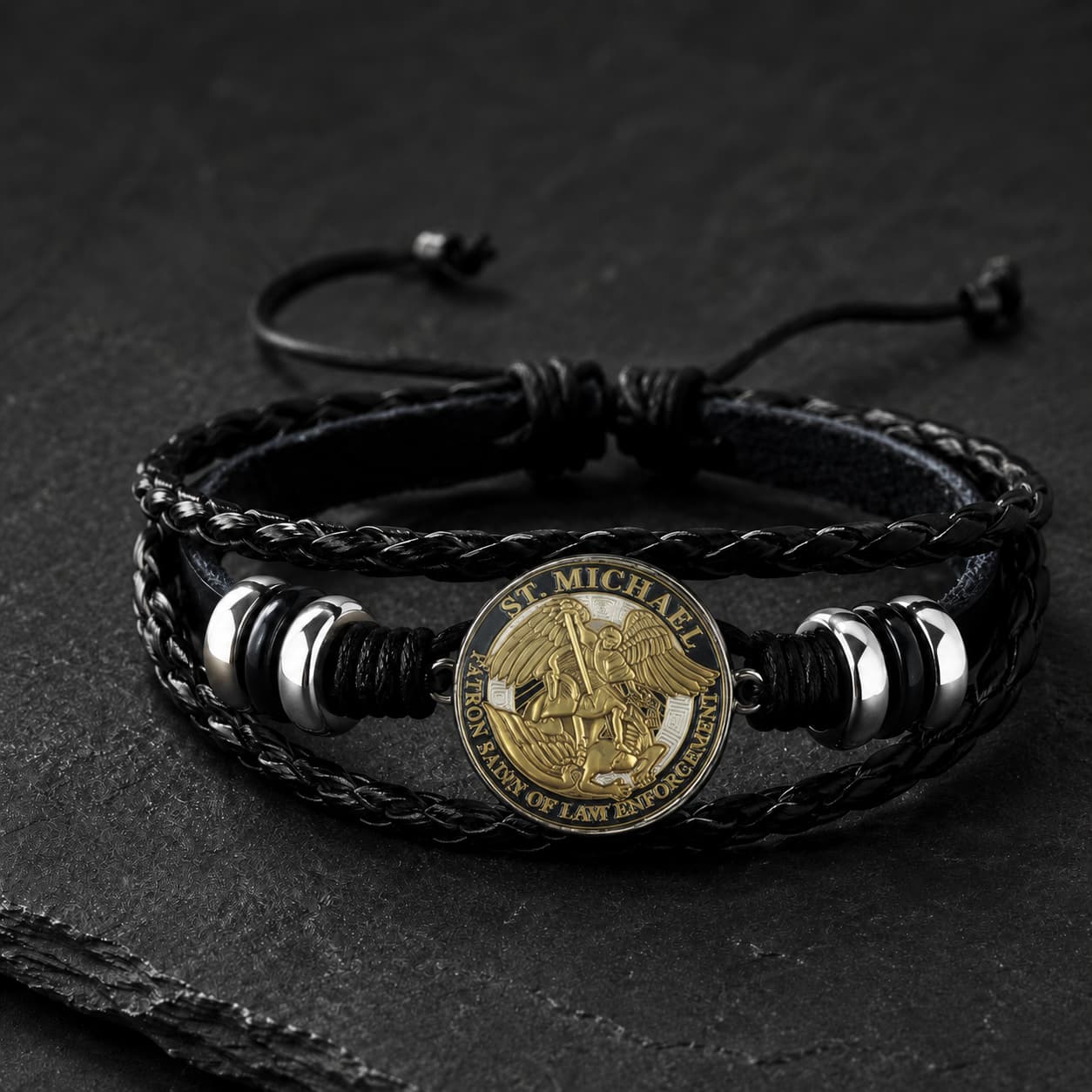 Bracelet de l’Archange Protecteur en cuir tressé noir avec médaille Saint Michel dorée et alliage métallique sur ardoise sombre