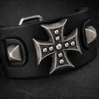 Gros plan du Bracelet de l’Armure du Templier avec croix métallique, rivets et cuir synthétique noir renforcé