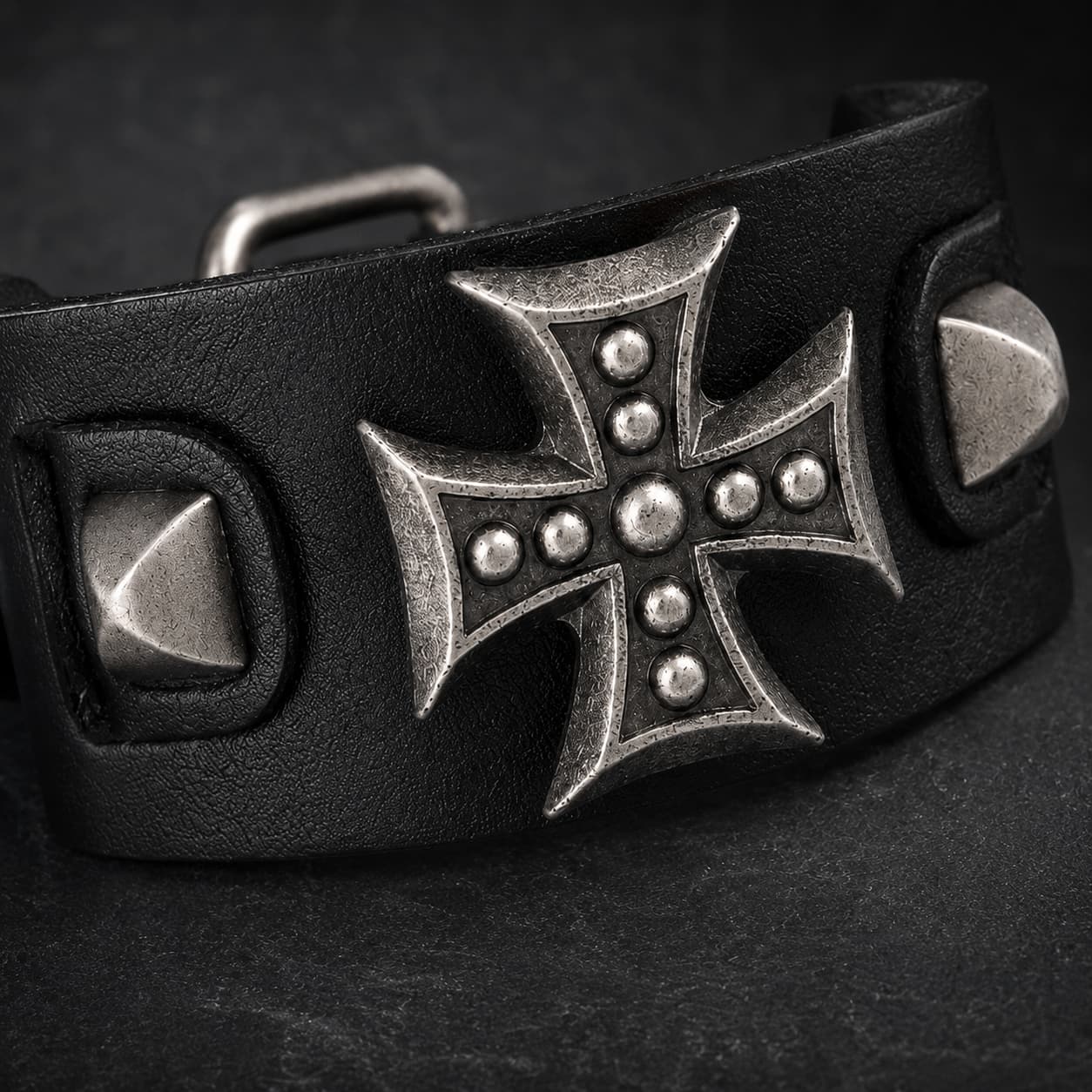 Gros plan du Bracelet de l’Armure du Templier avec croix métallique, rivets et cuir synthétique noir renforcé