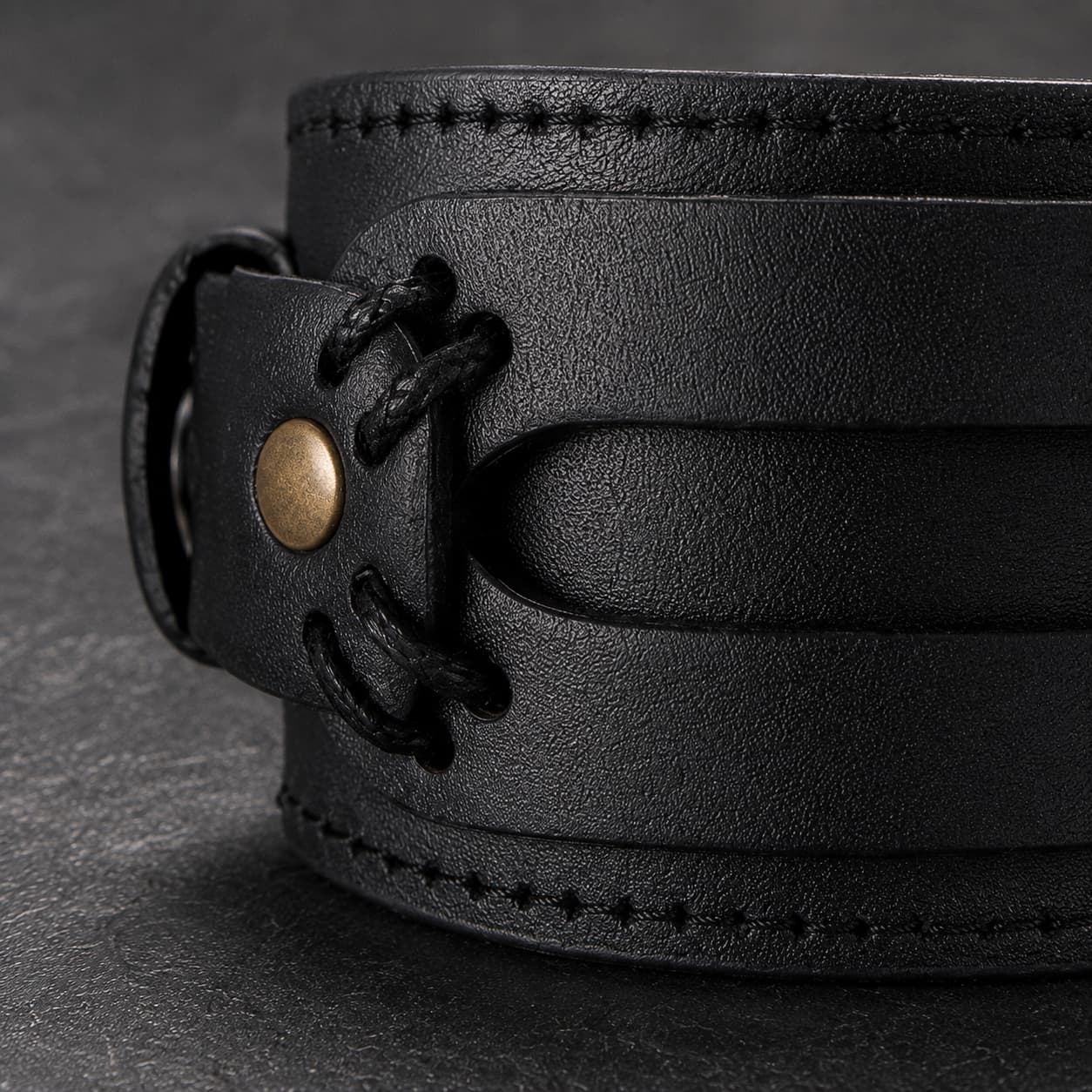 Gros plan du Bracelet de la Vaillance du Croisé avec cuir véritable noir renforcé, coutures, lacets et rivet en laiton vieilli