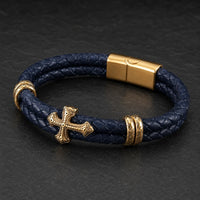 Bracelet du Commandeur Sacré en cuir premium tressé bleu marine avec croix dorée et fermoir en acier inoxydable, vue principale.