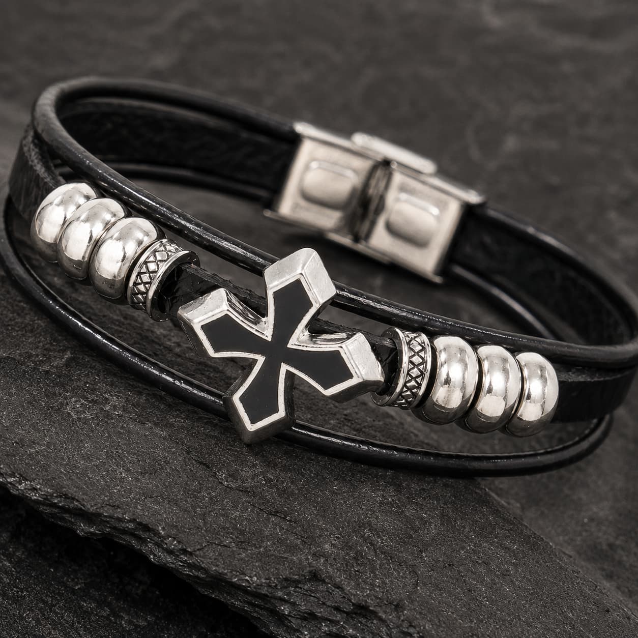 Gros plan du Bracelet du Fief Templier avec croix argentée, cuir premium noir et finitions en acier inoxydable