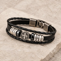 Bracelet du Vœu du Croisé en cuir tressé noir et alliage de zinc sur pierre médiévale claire