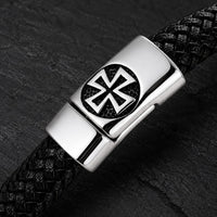 Gros plan de la croix templière du Bracelet de l’Élévation en cuir tressé noir et acier inoxydable
