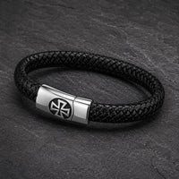 Vue angle 3/4 du Bracelet de l’Élévation en cuir tressé noir et acier inoxydable sur fond anthracite texturé