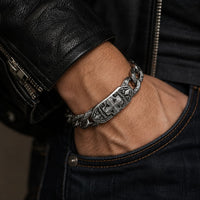 Bracelet Fleur du Temple en acier inoxydable porté par un homme avec veste en cuir noir et jean brut
