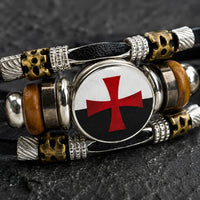 Gros plan du médaillon croix rouge du Bracelet Force du Temple en cuir tressé noir