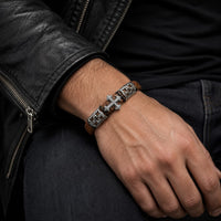 Bracelet de l’Indulgence porté au poignet par un homme avec cuir tressé marron et acier inoxydable