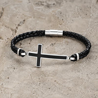 Bracelet de la Loyauté Sacrée en cuir tressé noir avec croix noire et acier inoxydable sur pierre médiévale claire