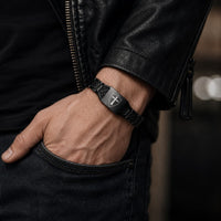 Bracelet Noir du Croisé porté par un homme avec veste en cuir noir et jean brut