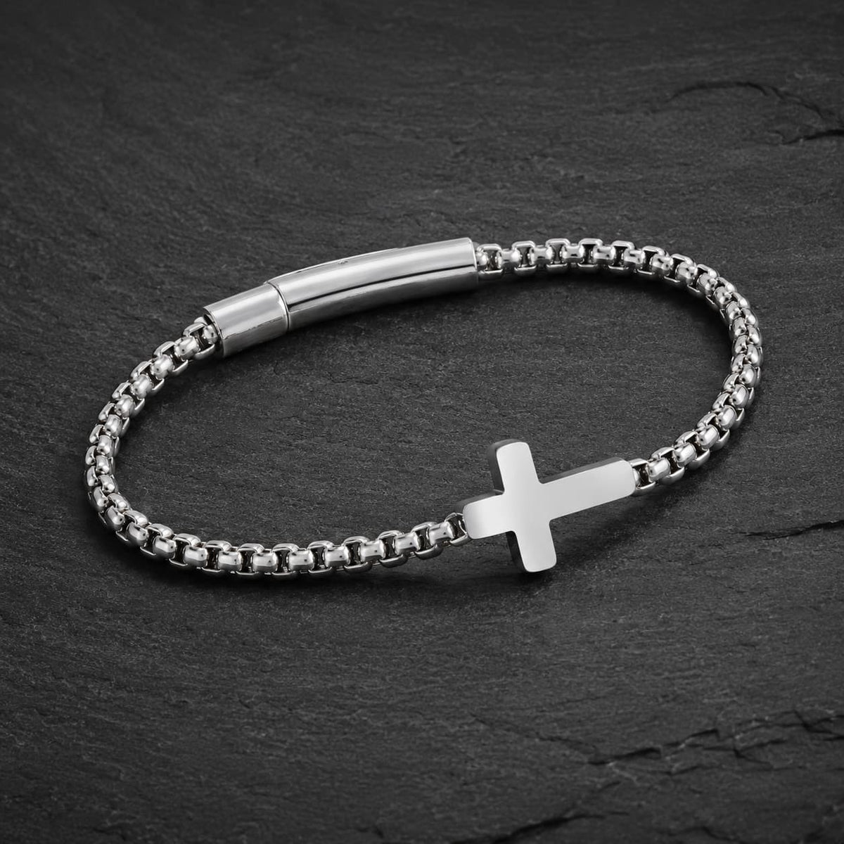 Bracelet du Pacte Sacré en acier inoxydable présenté en vue angle 3/4 sur ardoise sombre