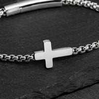 Gros plan du Bracelet du Pacte Sacré avec croix argentée et maillons en acier inoxydable