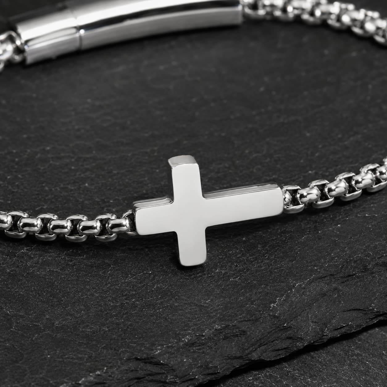 Gros plan du Bracelet du Pacte Sacré avec croix argentée et maillons en acier inoxydable