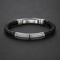 Bracelet du Primat Sacré en argent 925 sterling avec cuir tressé noir présenté en vue angle 3/4 sur ardoise sombre