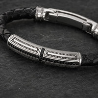 Gros plan du Bracelet du Primat Sacré avec motif en argent 925 sterling, détails gravés et cuir tressé noir
