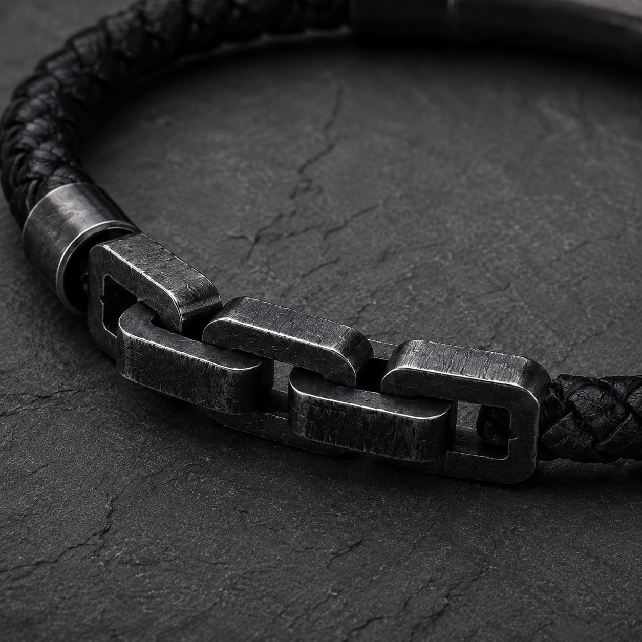 Gros plan du Bracelet de Robert de Craon avec maillons en acier inoxydable, cuir tressé noir et finition renforcée