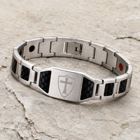 Vue angle 3/4 du Bracelet du Sacre Templier en acier inoxydable et fibre carbone sur pierre médiévale claire