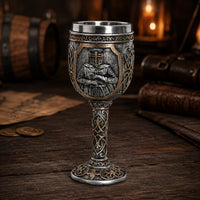 Calice du Festin Templier en résine et acier inoxydable présenté en vue angle sur une table en bois ancien sombre.